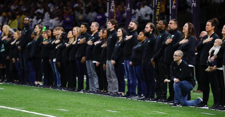 ‘Teacher of the Year’ Kneels in Protest during National Anthem at Championship Football Game Attended By Trump