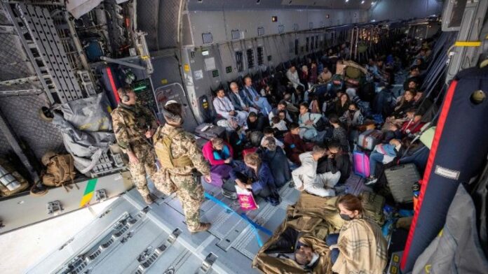 Afghan residents sit aboard a German military plane